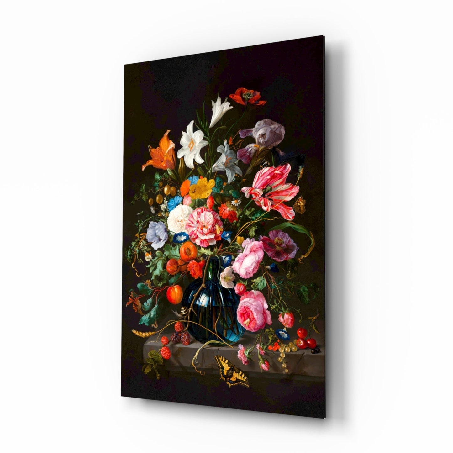 Angled product view of a glass wall art panel displaying a dark floral still life painting with pink roses, white flowers, orange blossoms, and a yellow butterfly against black background.