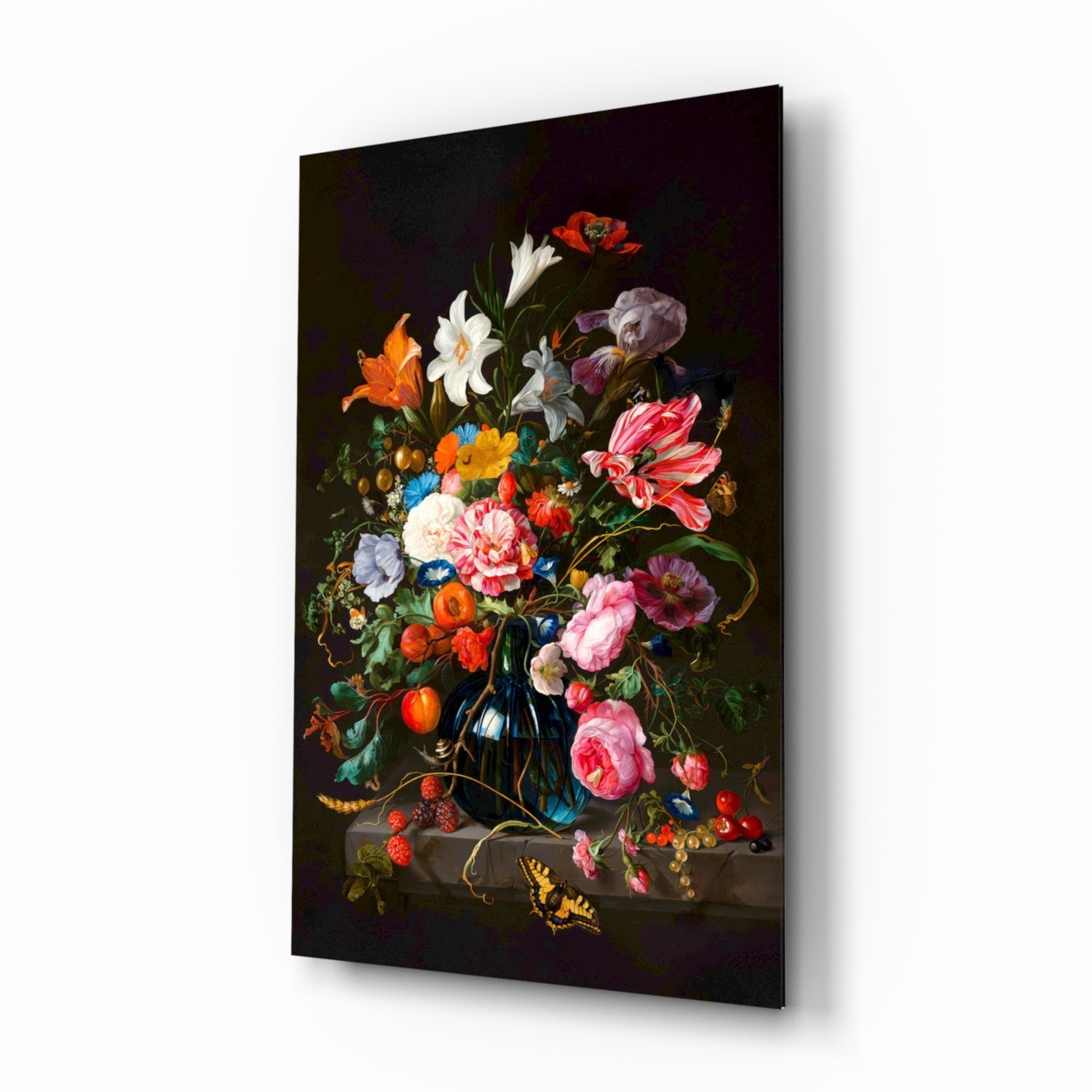 Angled product view of a glass wall art panel displaying a dark floral still life painting with pink roses, white flowers, orange blossoms, and a yellow butterfly against black background.