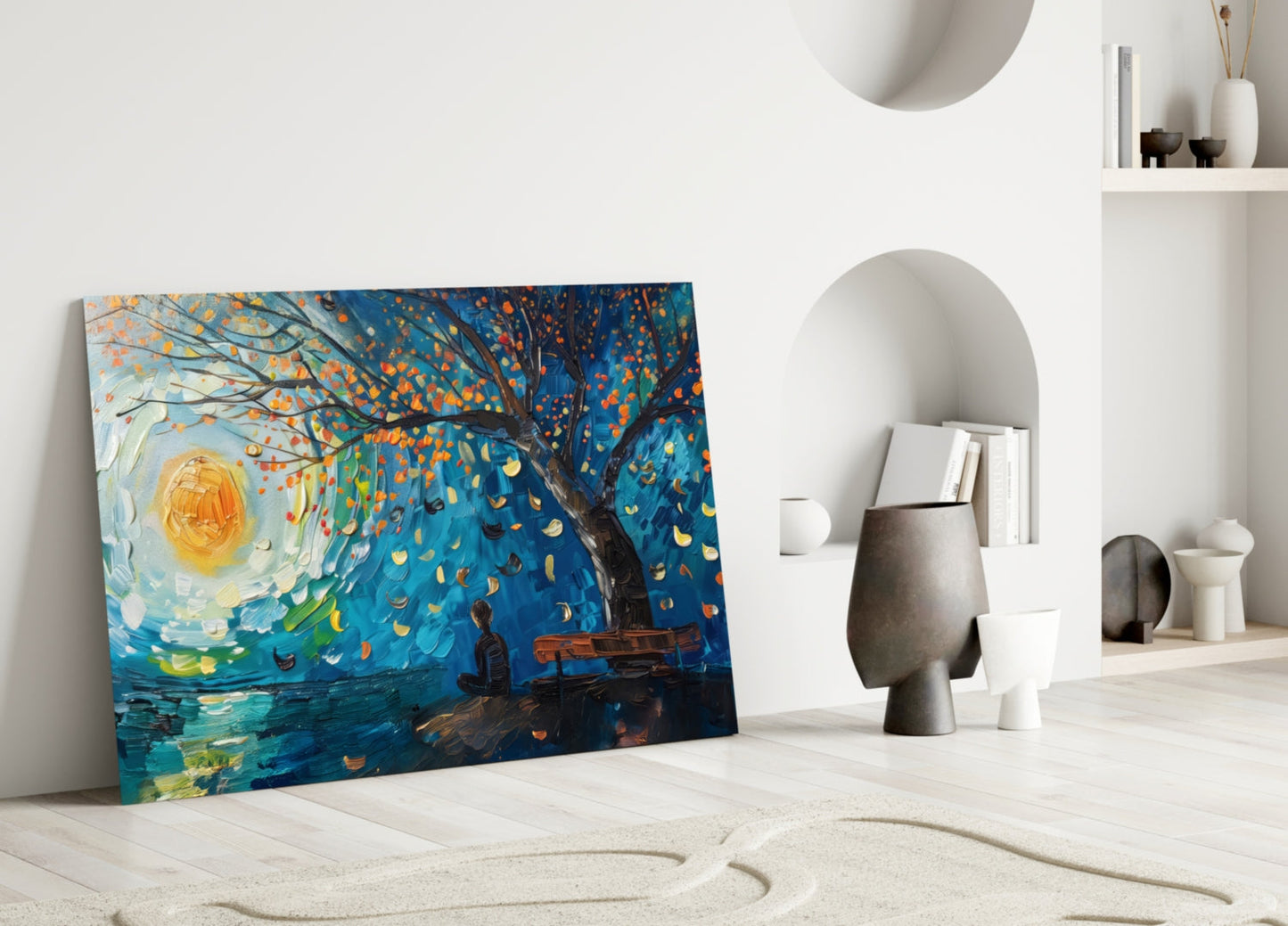 Colorful glass wall art depicting a moonlit tree with falling autumn leaves leans against a white wall in a minimalist interior setting.