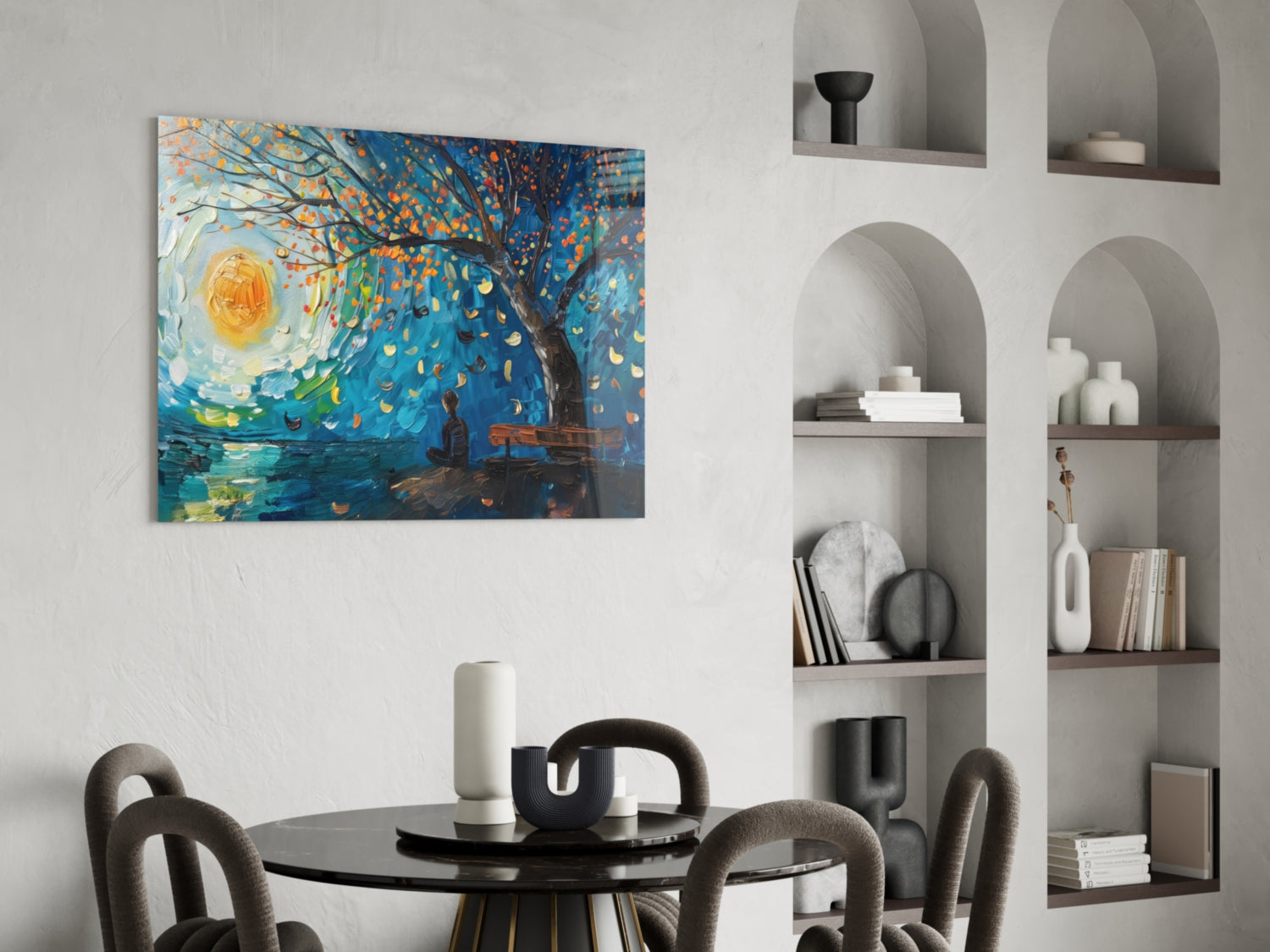 Vibrant glass wall art depicting a swirling blue sky with golden tree and yellow sun displayed above a round dining table in a modern interior setting.