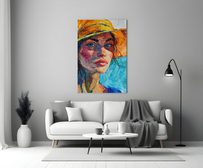 Colorful abstract portrait of woman wearing orange hat displayed above white sofa in minimalist living room setting.
