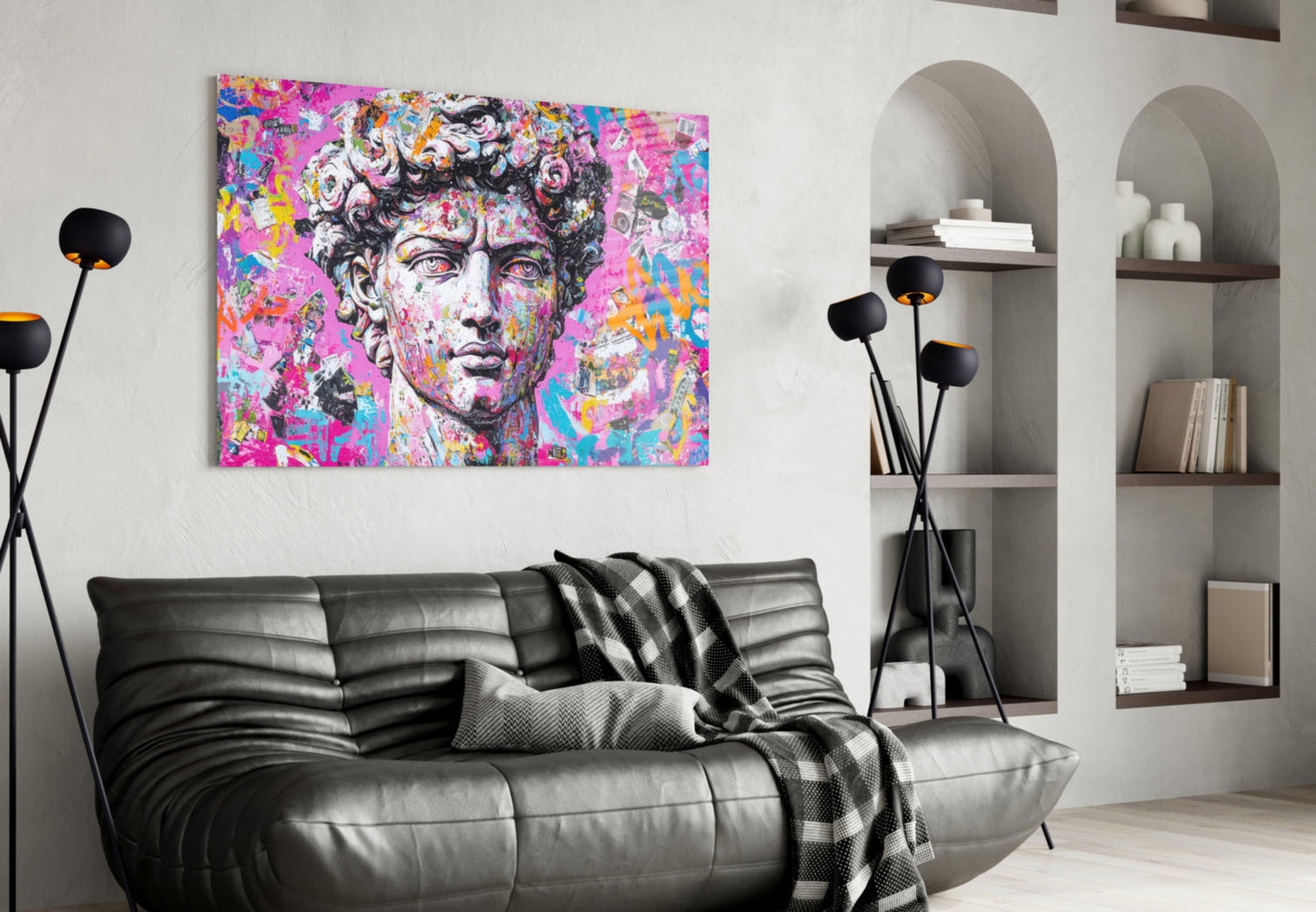 Vibrant pop art glass wall art depicting a classical bust with pink, blue, and yellow graffiti overlay, displayed above a black leather sofa in a modern living room.