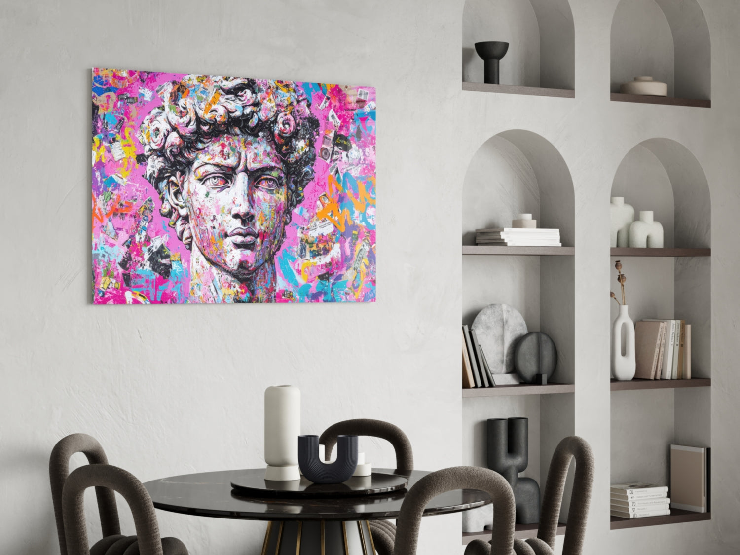 Colorful pop art glass wall panel featuring classical David bust with vibrant pink, blue, and yellow graffiti-style overlay, displayed above round black dining table in modern interior.