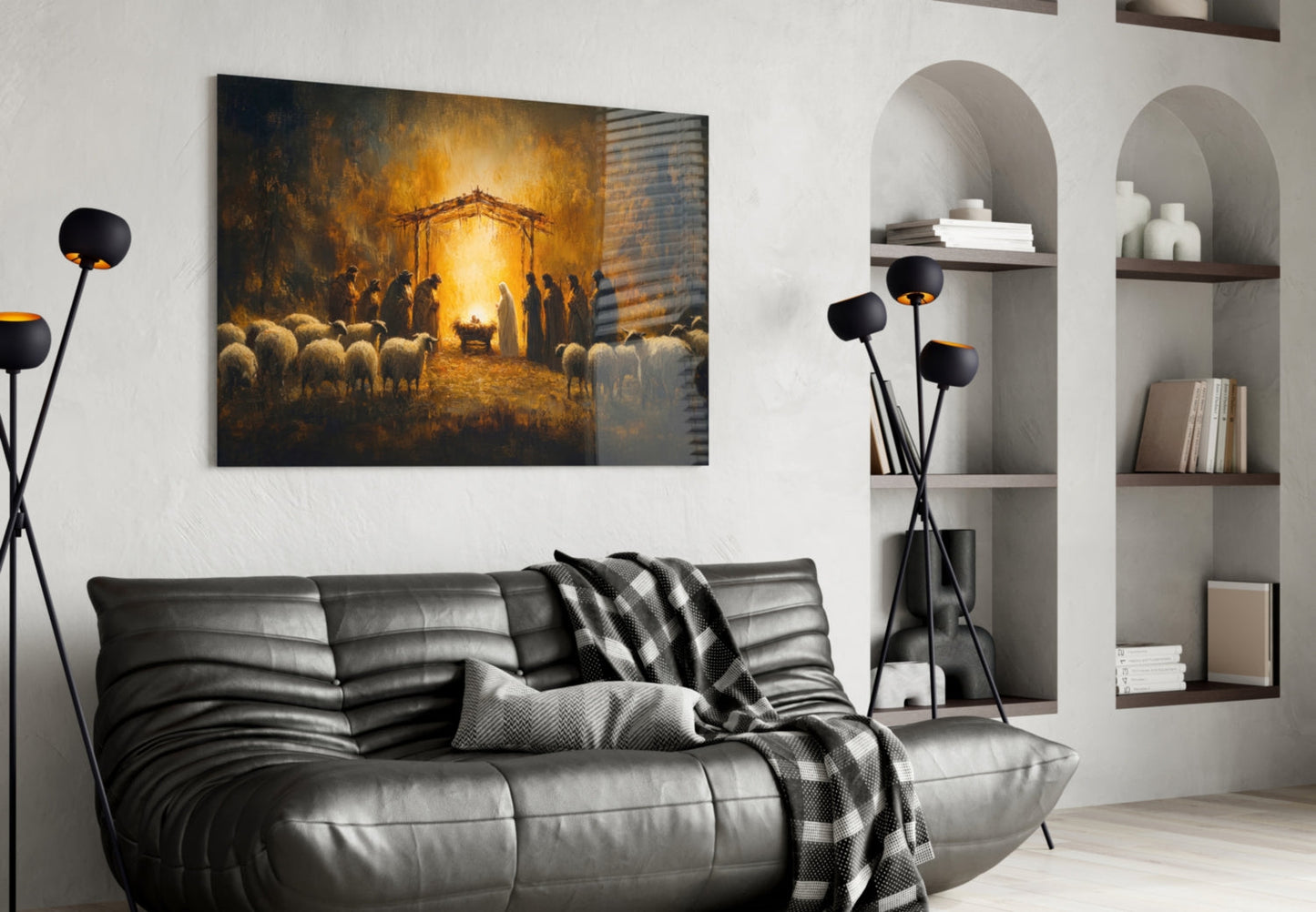 Modern living room with black leather sofa displaying Birth Glass Wall Art above, featuring golden nativity scene with sheep and figures.