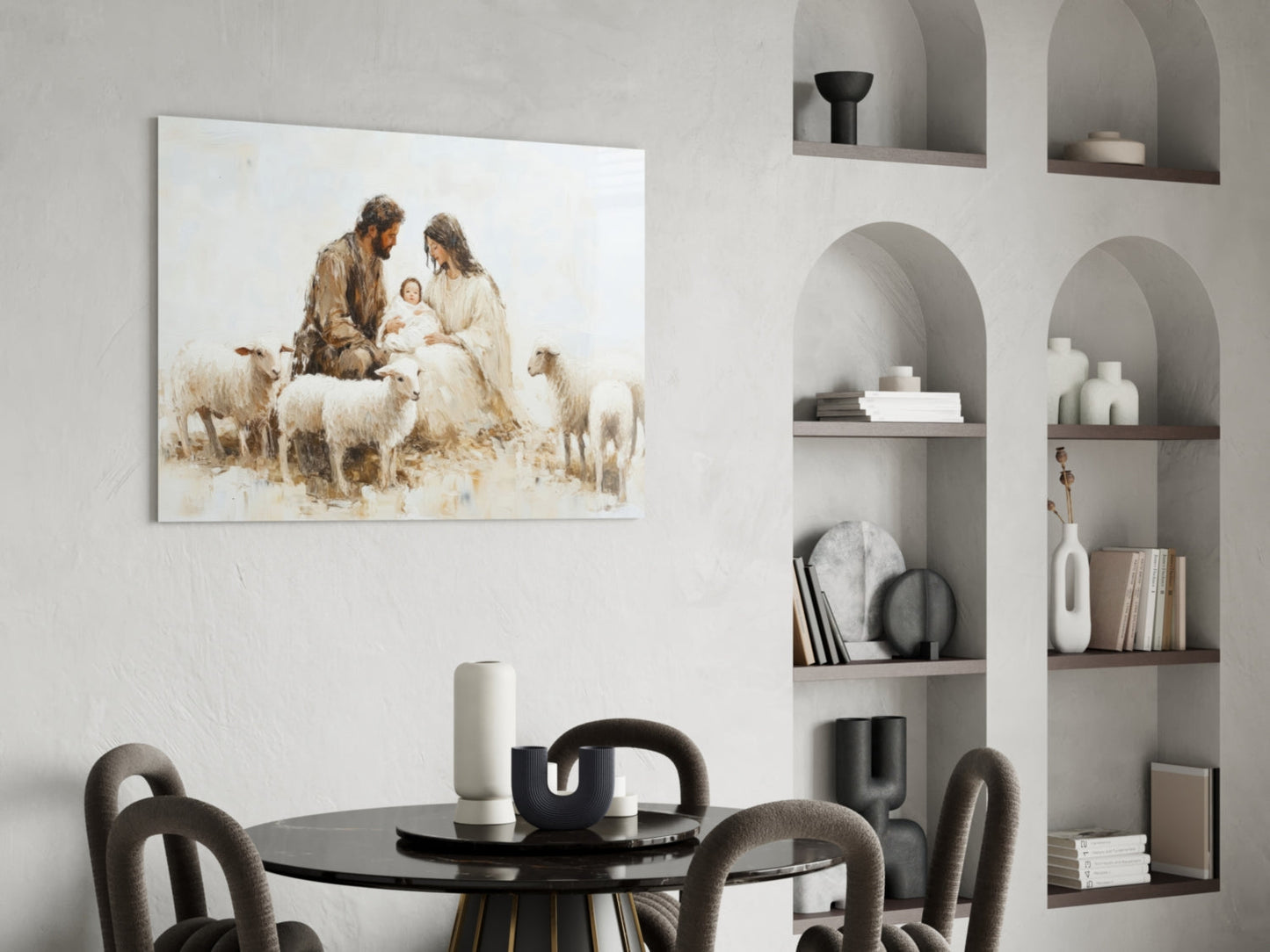 Glass wall art depicting nativity scene with shepherds and sheep in muted earth tones, displayed above round black dining table with gray chairs.
