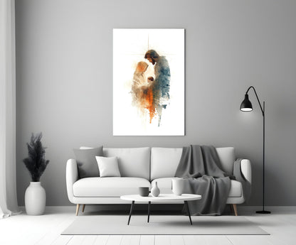 Holy Family glass wall art depicting two figures in watercolor tones displayed above white sofa in minimalist interior.