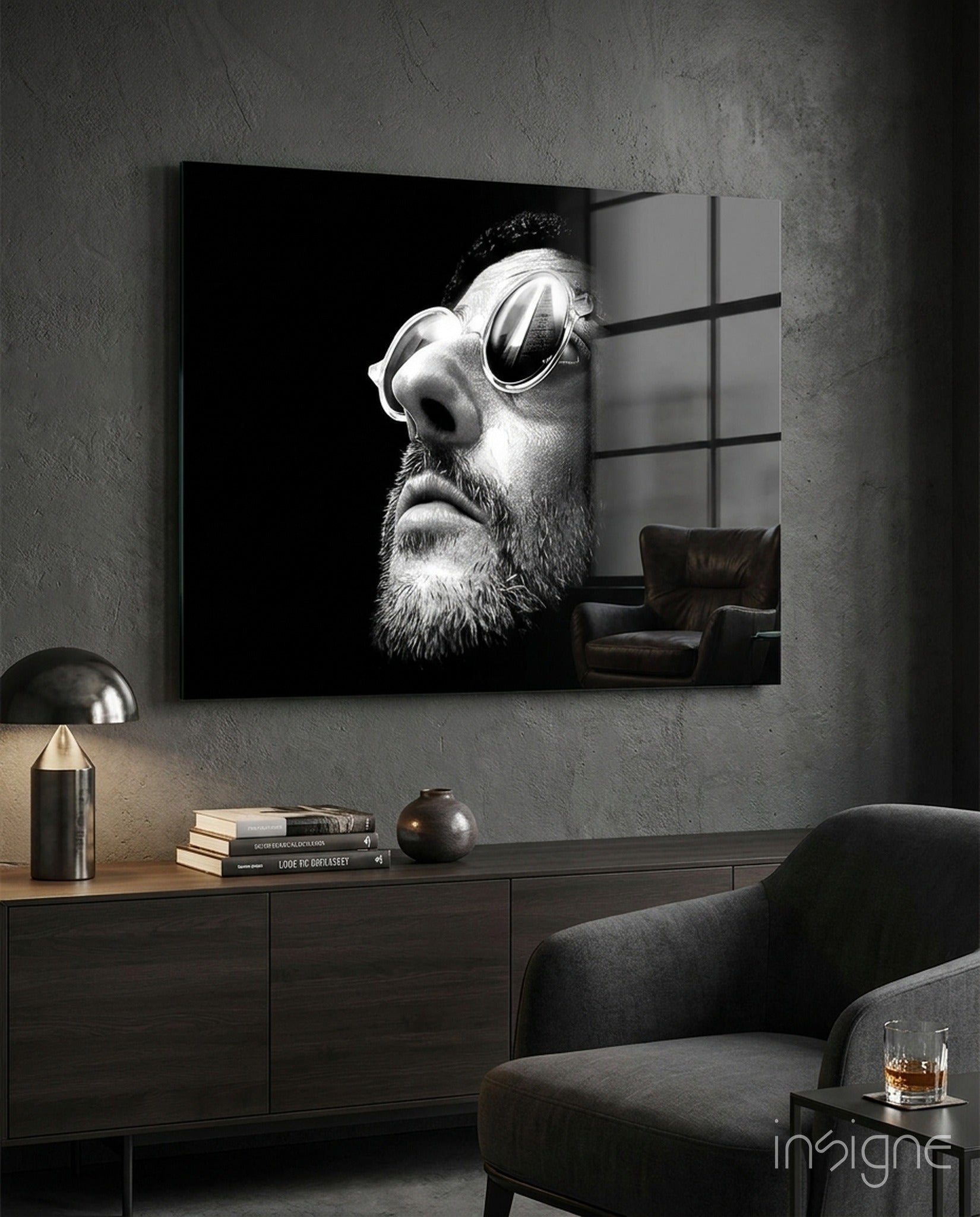 Black and white portrait of bearded man wearing oval sunglasses displayed as framed glass wall art above modern furniture.