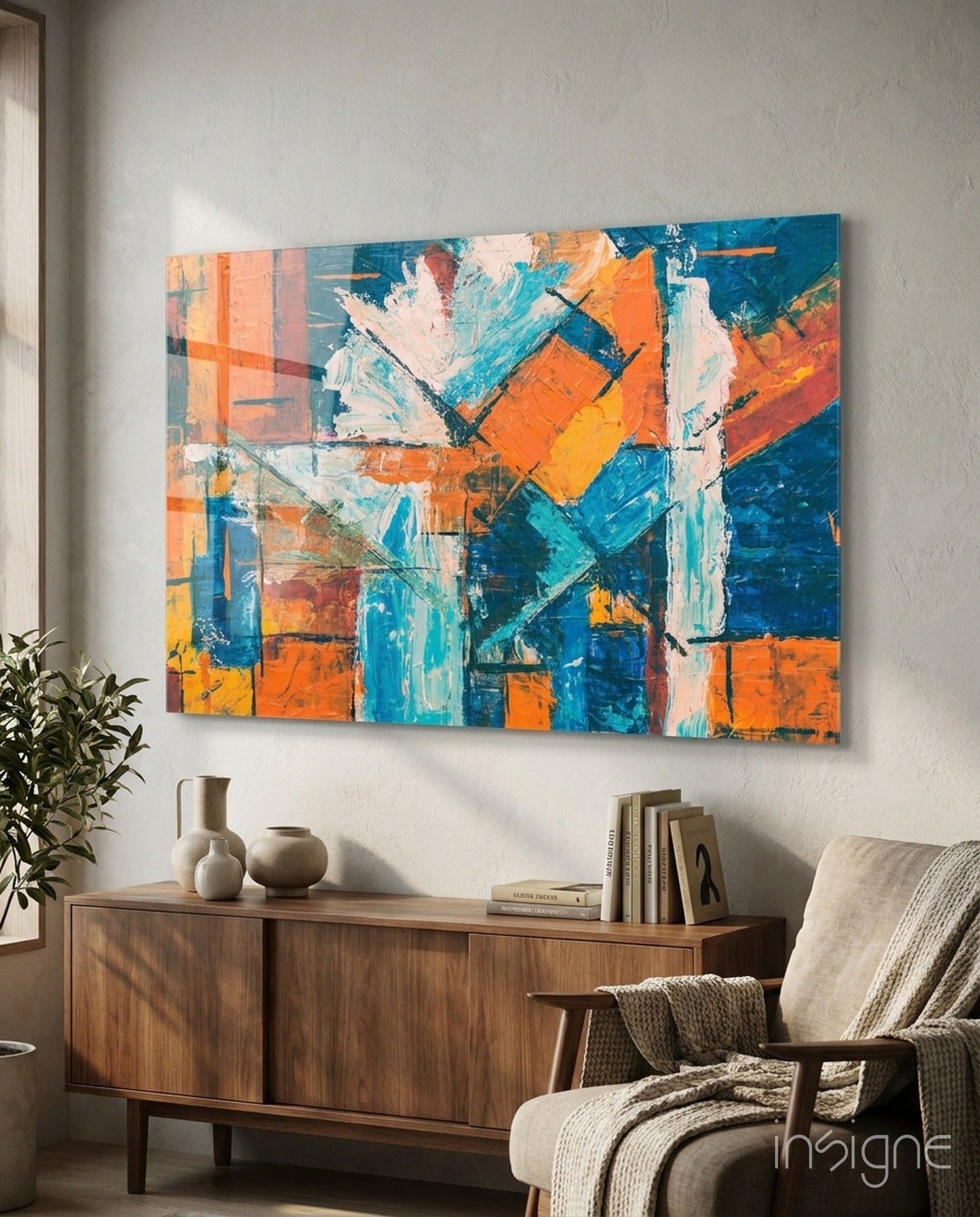 Abstract glass wall art with orange, blue, and white brushstroke patterns displayed above wooden dresser in mid-century modern room setting.