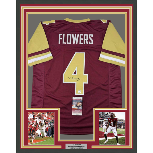 Framed back view of a maroon jersey with gold sleeves, white FLOWERS lettering, a gold number 4, and a black signature.