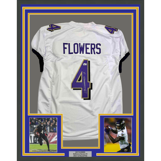 White Baltimore Ravens football jersey number 4 signed by Zay Flowers, displayed in frame with purple and gold borders and accompanying player photographs.