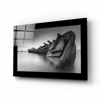 Black-framed glass wall art of weathered shipwreck boat in calm water