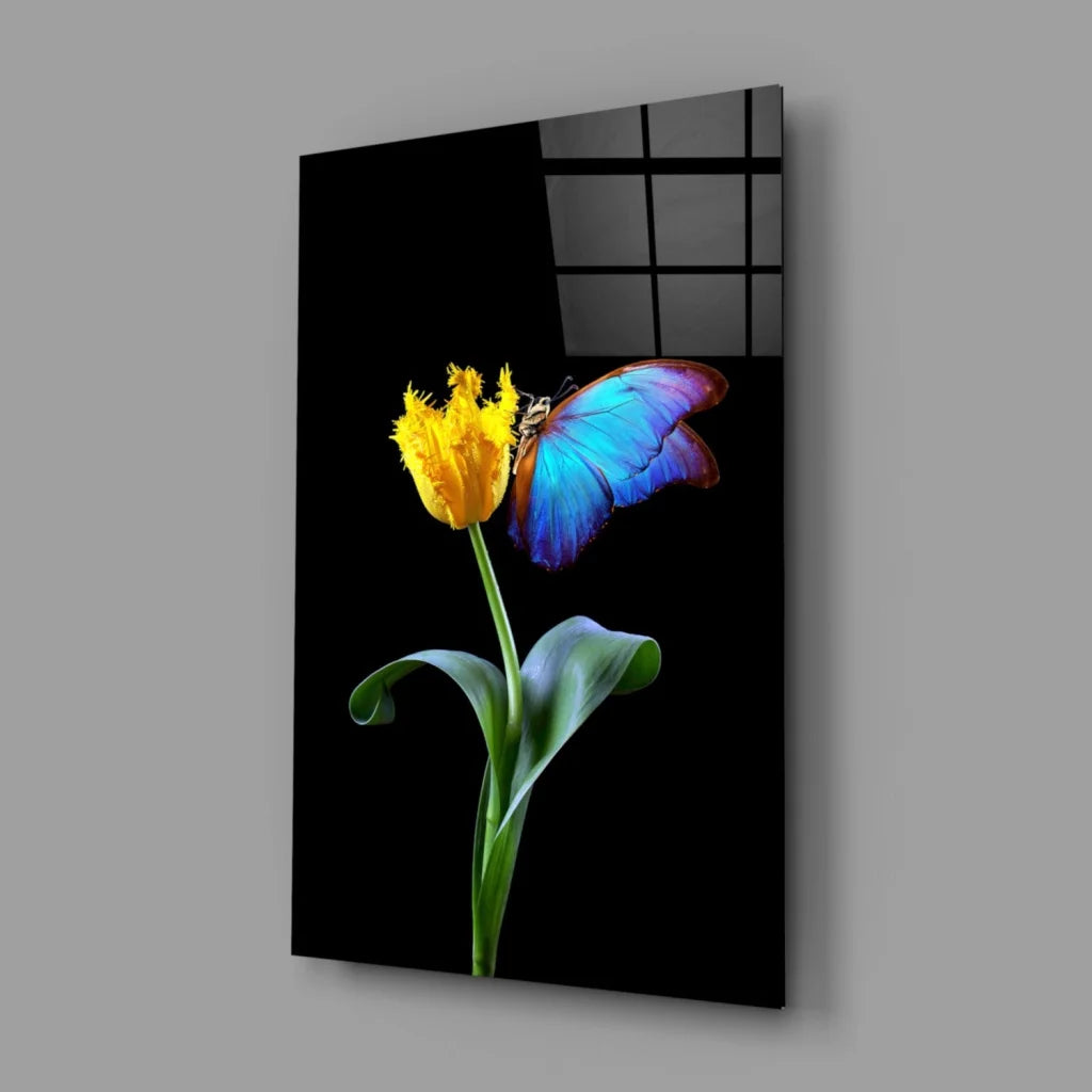 Vibrant yellow tulip with butterfly in glossy black-framed glass wall art