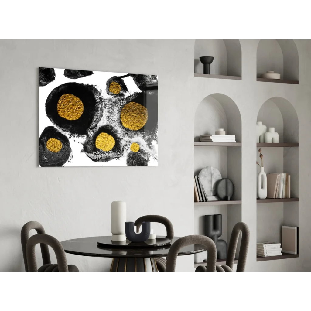 Black and gold abstract glass wall art with textured circular patterns on white wall