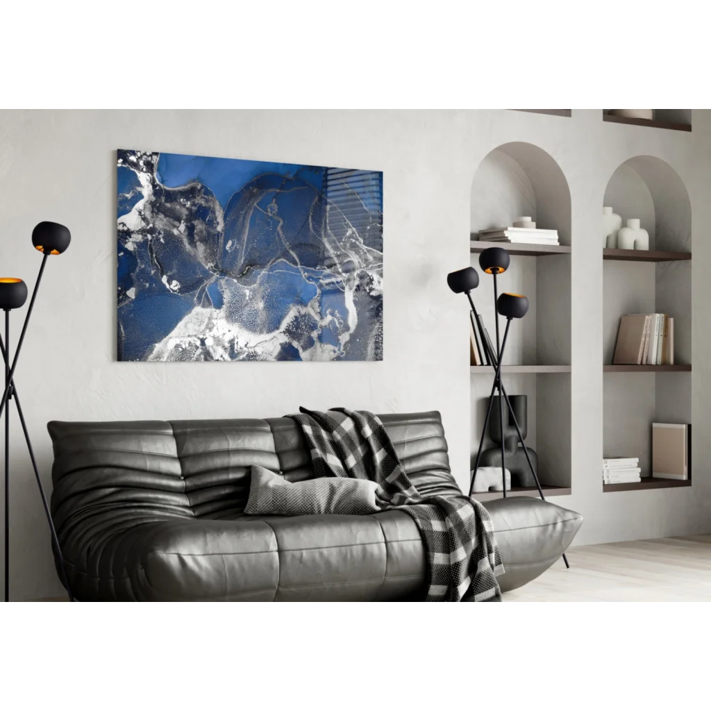 Blue and white abstract glass wall art above gray leather sofa