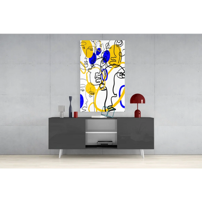 Bold yellow and blue abstract faces wall art on glass, geometric shapes framed in black