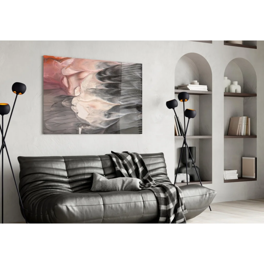 Modern black leather sofa with plaid throw under swirling pink and black wall art