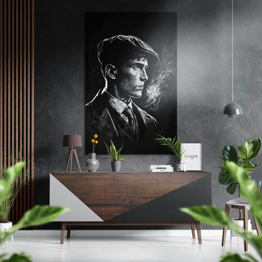 Black and white portrait of a man in a flat cap smoking, displayed on a dark wall above a wooden mid-century console table with plants and decor.