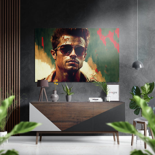 Modern interior room featuring a man wearing sunglasses displayed on brushed aluminum wall art above a wooden console table with plants and decor.