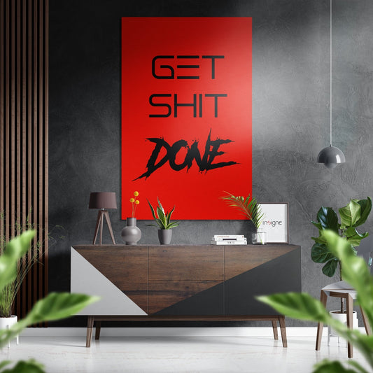 Red aluminum wall art with "GET SHIT DONE" text displayed above wooden console table in modern interior setting.