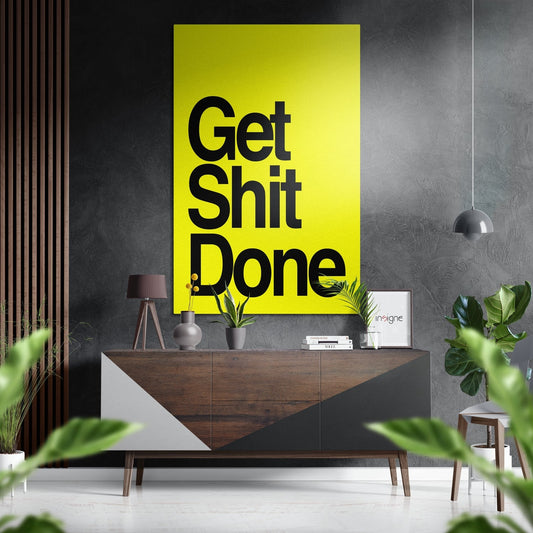 Modern interior room with bright yellow wall art displaying black text "Get Shit Done" above wooden credenza with plants and decor.