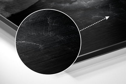 Close-up of brushed aluminum dibond wall art showing circular black textured design with white border and directional arrow on gray background.