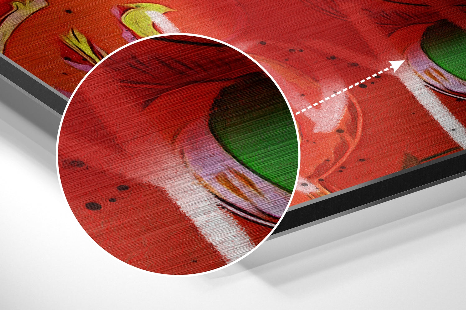 Close-up detail of brushed aluminum wall art showing red surface with green leaf design and magnified circular inset revealing texture and layered colors.