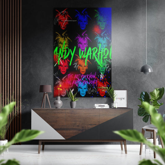 Vibrant neon pop art portrait grid with colorful face reproductions and green "ANDY WARHOL" text displayed above wooden dresser in modern interior.