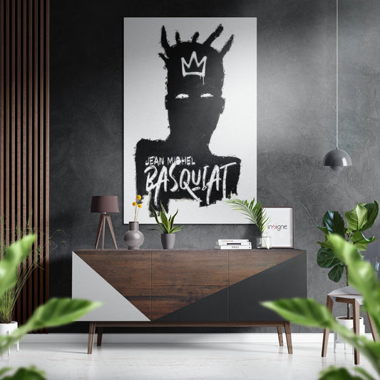 Modern interior showroom featuring black and white Basquiat portrait artwork displayed above wooden console table with plants and pendant lighting.