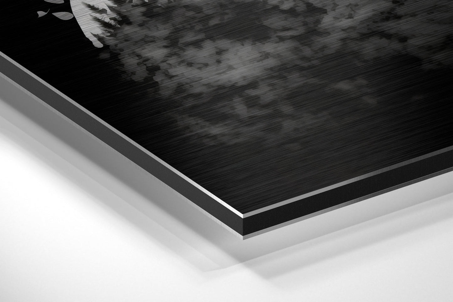 Close-up angled view of layered Dibond panel edges showing brushed black aluminum surface with white backing material.