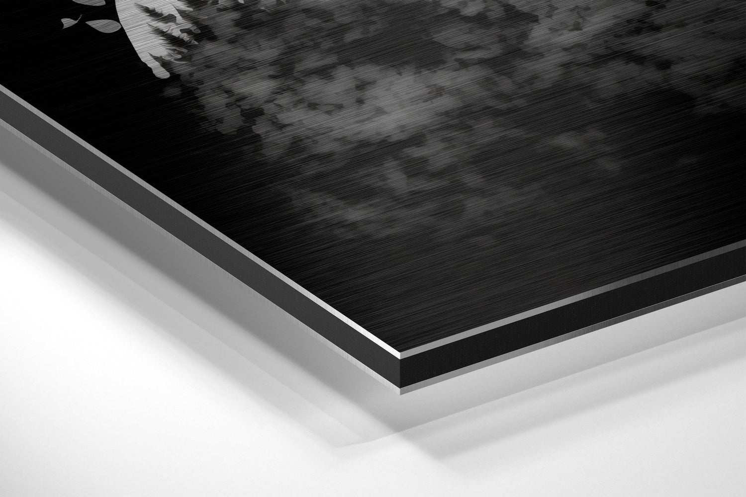Close-up angled view of layered Dibond panel edges showing brushed black aluminum surface with white backing material.