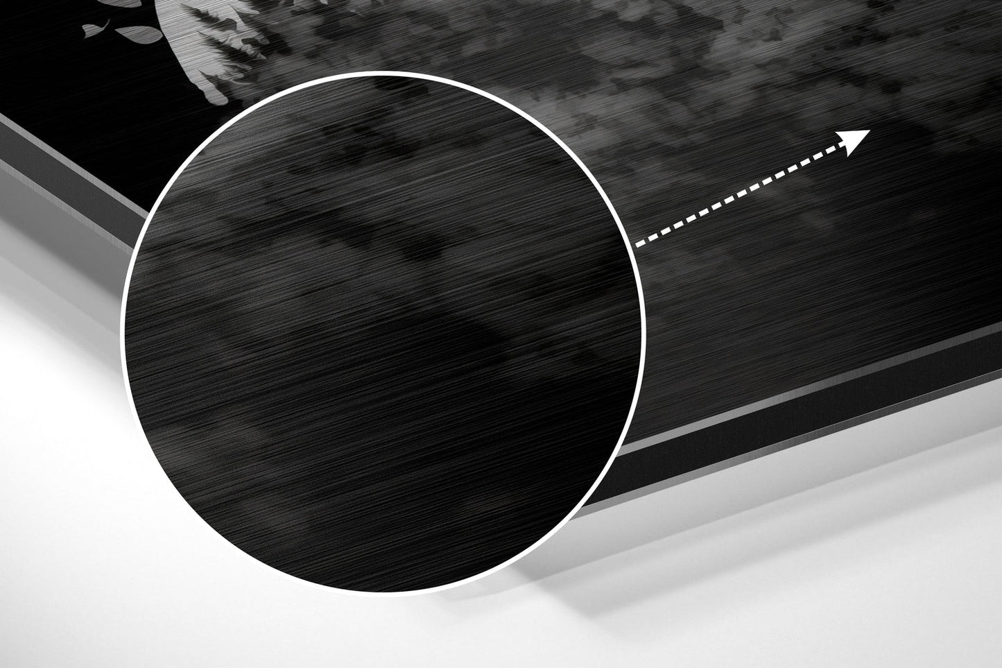Close-up angled view of brushed aluminum Dibond wall art showing circular black textured center with white border and directional arrow detail.