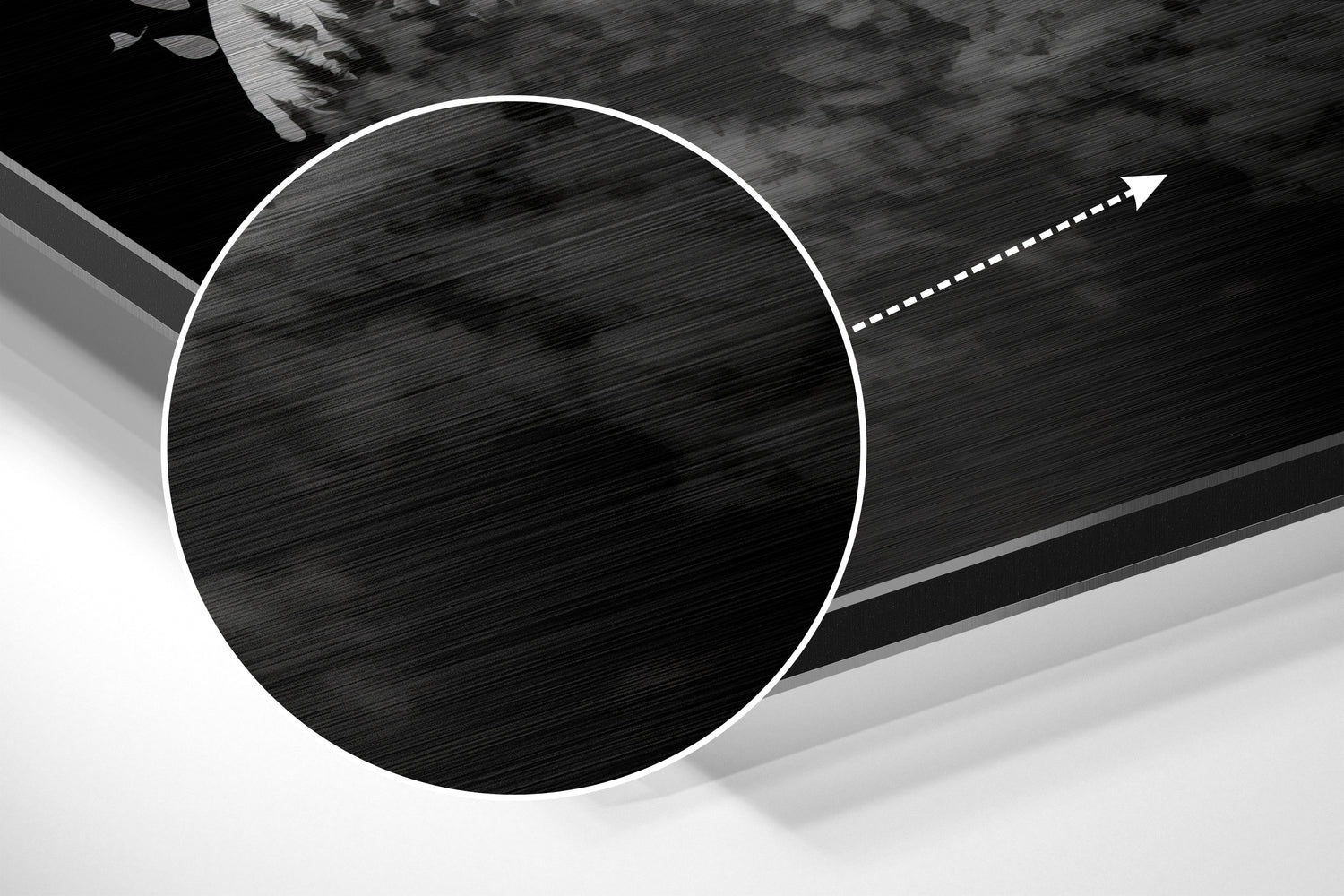 Close-up angled view of brushed aluminum Dibond wall art showing circular black textured center with white border and directional arrow detail.
