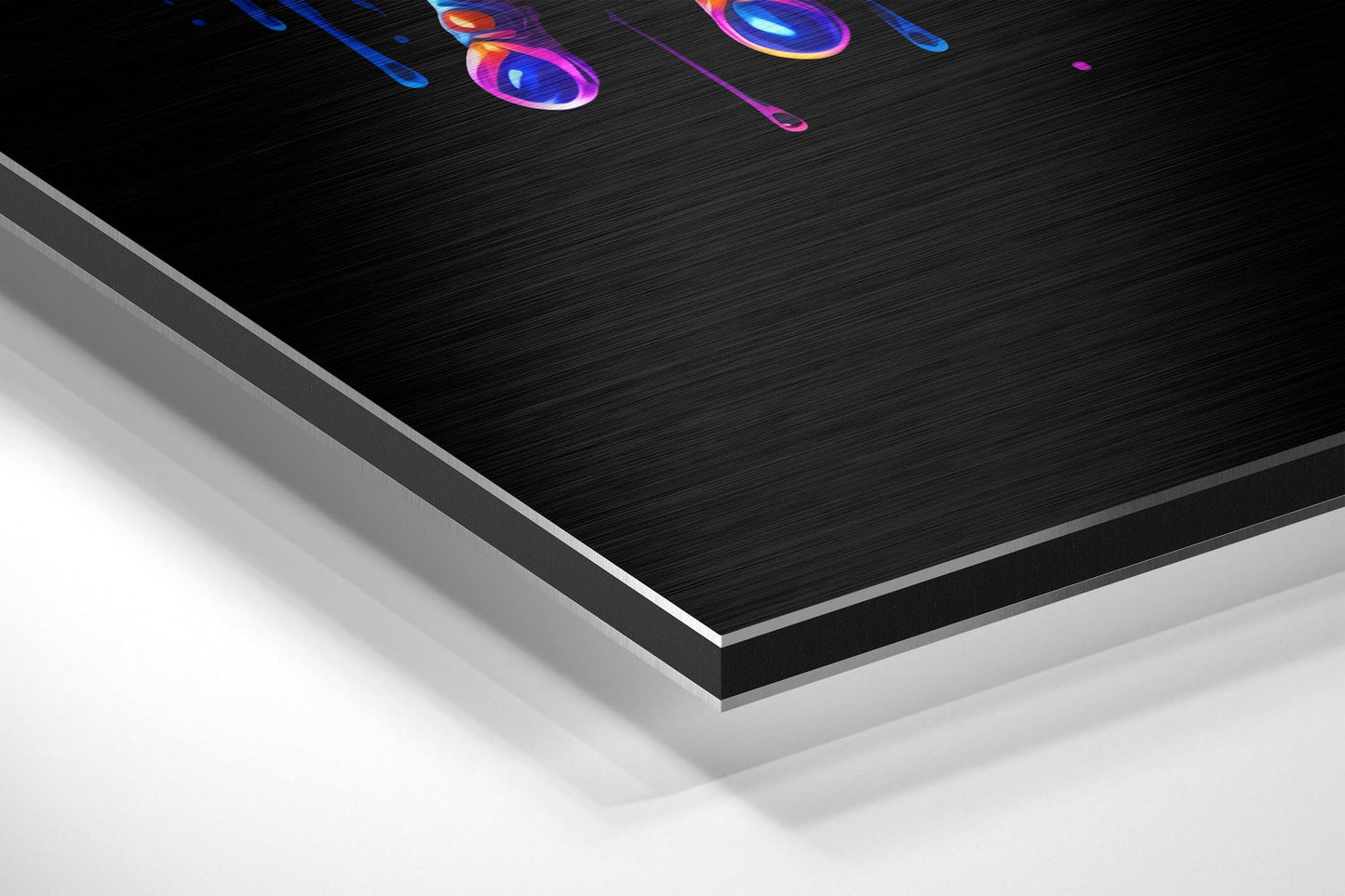 Angled perspective shot of layered Dibond wall art with brushed black aluminum surface and neon colorful abstract design elements at top.