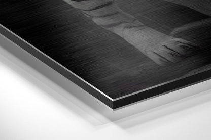Close-up angled view of layered Dibond panel showing brushed black aluminum surface with white backing layers and silver edge trim.
