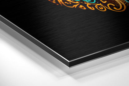 Close-up angled view of layered brushed aluminum and white backing of skull wall art with orange and teal decorative design.