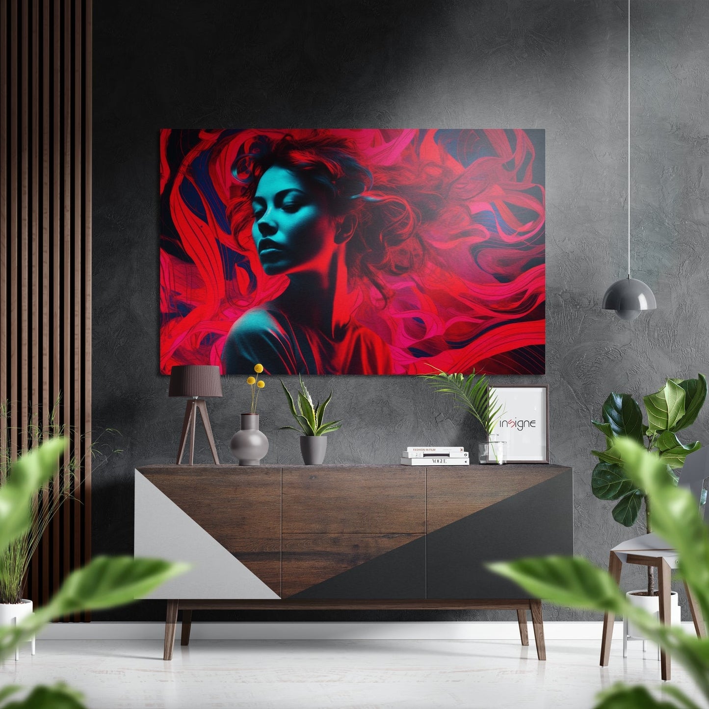 Modern interior setting with vibrant red and cyan abstract portrait artwork mounted above wooden sideboard with decorative objects and plants.