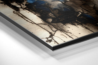 Close-up angled view of brushed aluminum Dibond wall art with black frame edge, showing tree branch shadows on light wood surface.