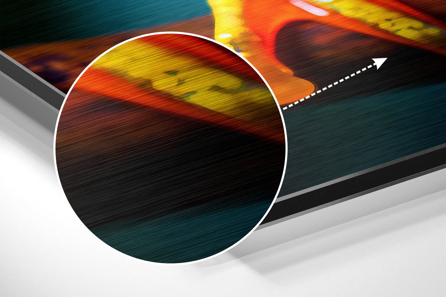 Close-up angled view of brushed aluminum wall art showing vibrant red, yellow, and teal gradient with directional arrow detail.
