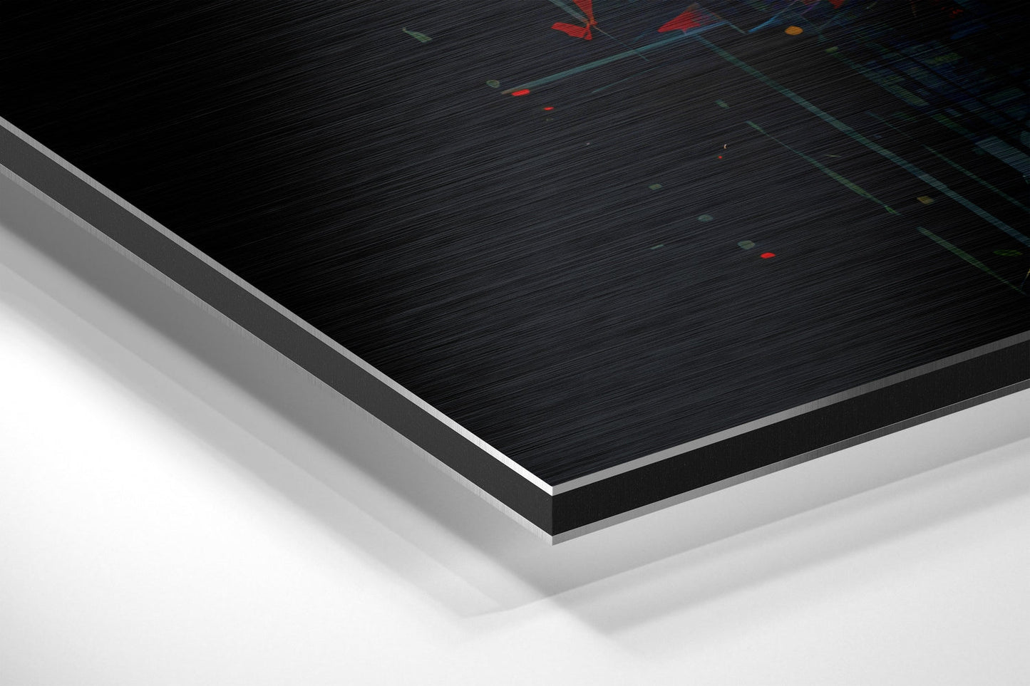 Close-up angled view of brushed aluminum Dibond panel edge showing black brushed surface with colored light reflections and white layered backing material.