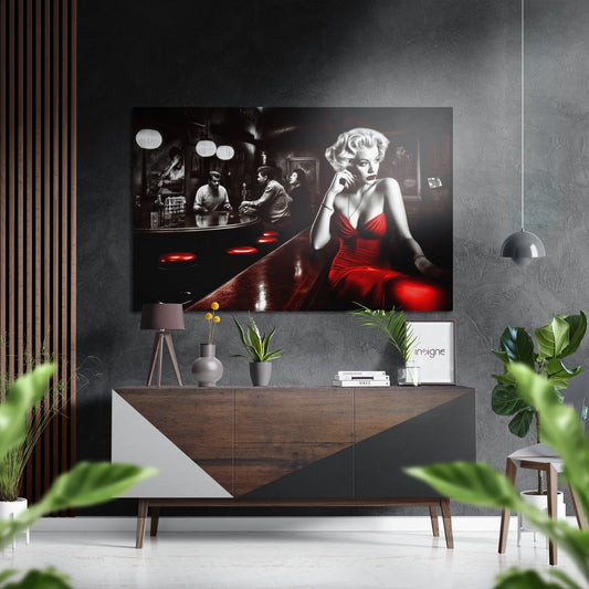 Black and white photograph with red accent showing woman in red dress at bar, displayed above wooden credenza in modern interior setting.