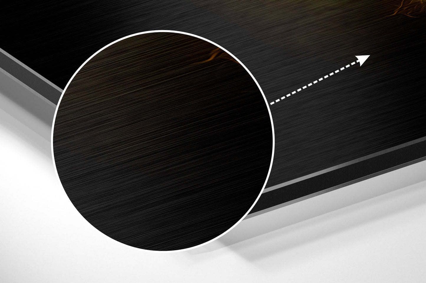 Angled view of brushed black aluminum circular wall art with white border and directional arrow on dark background.