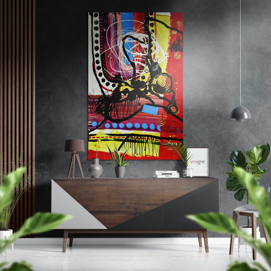 Colorful abstract wall art with red, yellow, and blue geometric shapes displayed above a mid-century wooden console table in a modern interior setting.