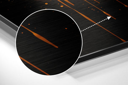 Close-up detail view of brushed aluminum surface with orange diagonal lines and white circular frame highlight against dark background.