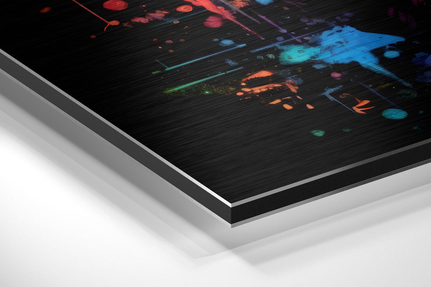 Angled closeup of brushed aluminum Dibond wall art showing layered edge construction with vibrant multicolored digital artwork on black surface.