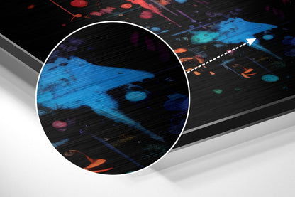 Close-up detail of brushed aluminum surface showing blue and orange digital abstract design with horizontal texture lines.