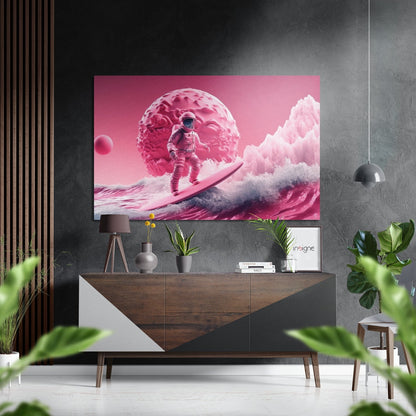 Surreal pink landscape artwork featuring an astronaut on a surfboard near a giant brain-shaped planet, displayed above a wooden console table in a modern interior.