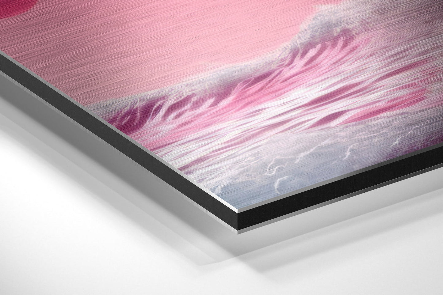 Close-up angled view of layered brushed aluminum and black edge framing pink and blue wave artwork.