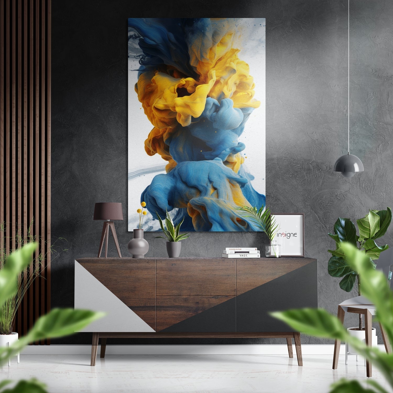 Vibrant blue and yellow ink swirls displayed on brushed aluminum panel above mid-century wooden console in modern interior setting.