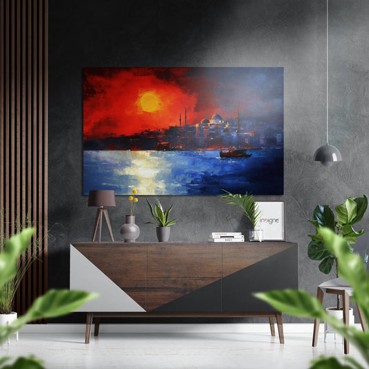 Modern living room displaying a horizontal brushed aluminum wall art panel showing an Istanbul sunset with red sky, blue water, sailboat, and mosque silhouette above a wooden dresser with plants and accessories.