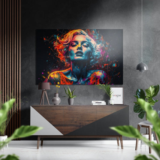 Colorful abstract portrait of a woman with vibrant orange, pink, and blue paint splatter effects displayed above a wooden console table in a modern living room.